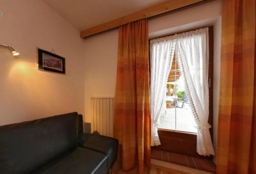 a living room with a couch and a window at Ferienwohnungen Haaser in Maurach