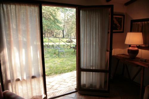 an open sliding glass door with a view of a yard at Malvarina in Capodacqua