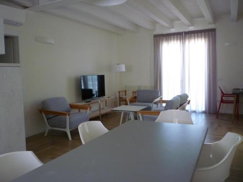 a living room with a table and chairs and a television at Residence Atlantico in Lido di Jesolo