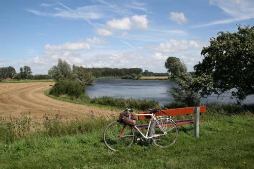 a bike parked next to a bench next to a river at Boutique hotel Shamon in Eeklo
