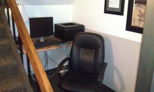 a desk with a chair and a computer monitor at Super 8 by Wyndham Newburgh/West Point Stewart Intl Airport in Newburgh