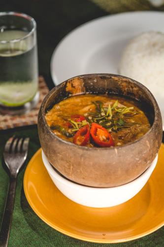 a bowl of soup on a plate on a table at Terres Rouges Lodge in Banlung