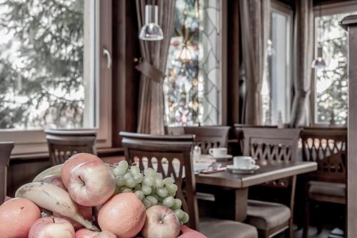 a dining room with a table with a bowl of fruit at Hotel Garni Caroline in Ischgl