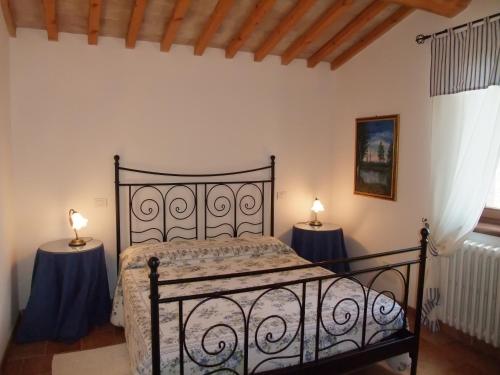 ファブロにあるAgriturismo Pian di Frattinaのベッドルーム1室(ベッド1台、テーブルにランプ2つ付)