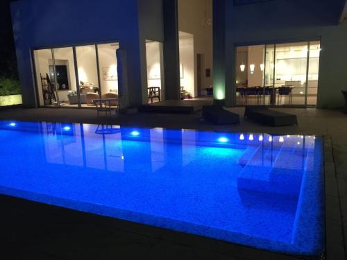 a swimming pool with blue lights in a house at Villa Alice Caesarea in Caesarea