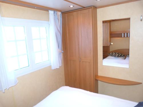 1 dormitorio con cama y ventana en Mobilheim Seezauber en Uttendorf