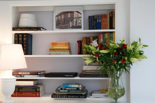 a vase of flowers on a table with books at Saddlers B&B in Funtington