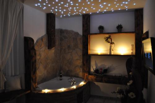 a bathroom with a tub and a mirror and lights at Ubytování Cukrovar in Lovosice