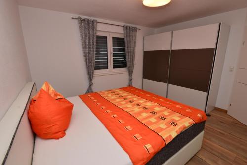 シェッファウ・アム・ヴィルデン・カイザーにあるFerienwohnung Widmannのベッドルーム1室(オレンジ色の枕付きのベッド1台付)