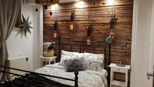 1 dormitorio con 1 cama con pared de madera en Apartament PREMIUM Blanka en Poronin
