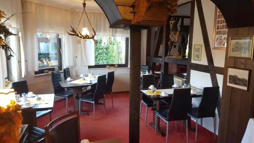 un comedor con mesas y sillas en un restaurante en Frau Holle-Land-Hotel ehem Burghotel Witzenhausen, en Witzenhausen