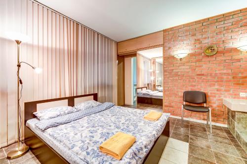 a bedroom with a bed and a brick wall at STN on Karavannaya in Saint Petersburg