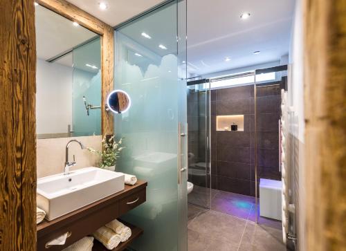 La salle de bains est pourvue d'un lavabo et d'une douche. dans l'établissement Appartements Plattnerhof, à Castelrotto