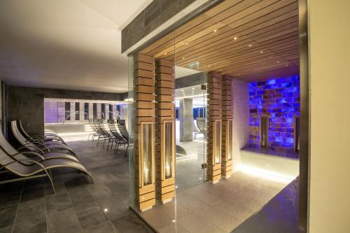 a restaurant with chairs and a bar with blue lights at Bonvital Hotel Hévíz Superior Adults Only in Hévíz