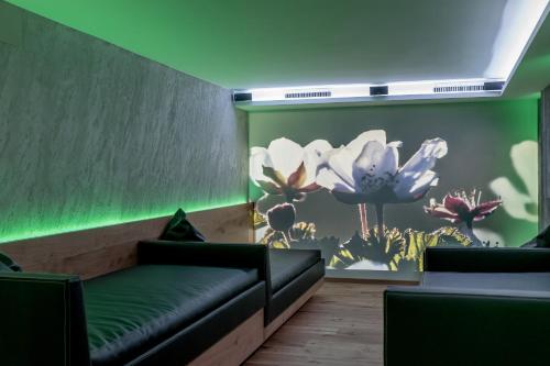 a waiting room with a couch and flowers on the wall at Hotel Garni Caroline in Ischgl