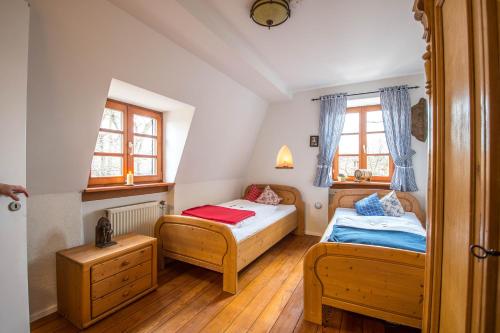 a bedroom with two beds and two windows at Schloss Auerbach Große Ferienwohnung in Bensheim