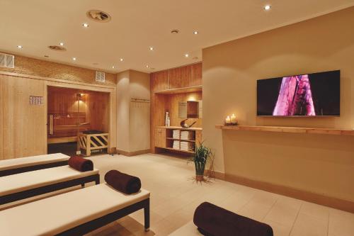 a room with two beds and a flat screen tv at H+ Hotel Hannover in Hannover