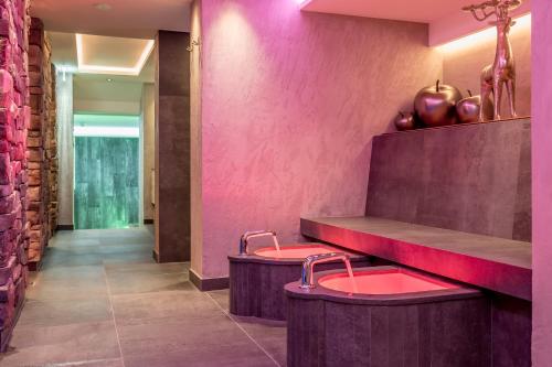 a restaurant with pink walls and red stools at Hotel Garni Caroline in Ischgl