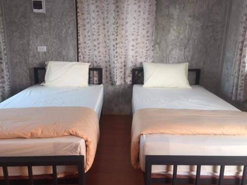 two twin beds in a room withermottermott at BN Resort in Ban Nong Chum Saeng