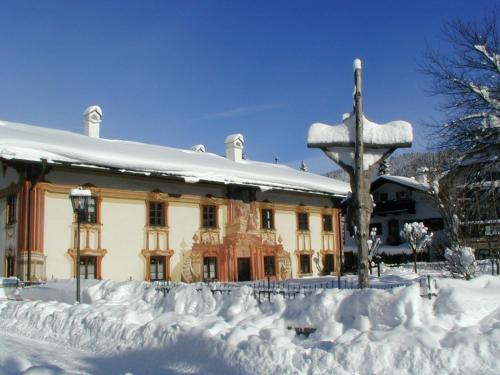 a building covered in snow in front at Mammhofer Suite & Breakfast in Oberammergau
