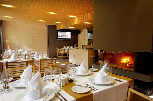 a restaurant with tables with white plates and napkins at Lucky Bansko Aparthotel SPA & Relax in Bansko
