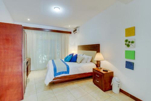 1 dormitorio con 1 cama con almohadas azules en Ocotal Beach Club Hotel 1, en Guanacaste