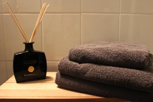 a pile of towels on a table next to a bottle of soap at B&B Anna's in Bruges