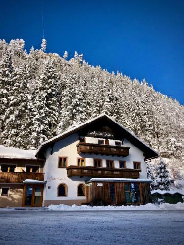 a building with snow covered trees on a mountain at Gasthof Salzstadl in Reutte