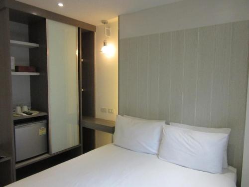 a bedroom with a bed with white pillows at Urban house in Bangkok