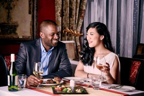a man and woman sitting at a table in a restaurant at Peermont D'oreale Grande at Emperors Palace in Kempton Park