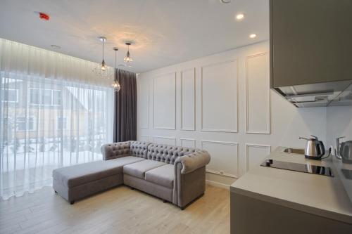 a living room with a couch in a kitchen at Nikolas Apartamentai - Birstono 7 in Druskininkai