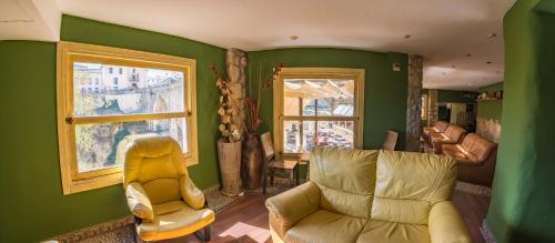 a living room with a couch and a chair at Hotel Don Miguel in Ronda