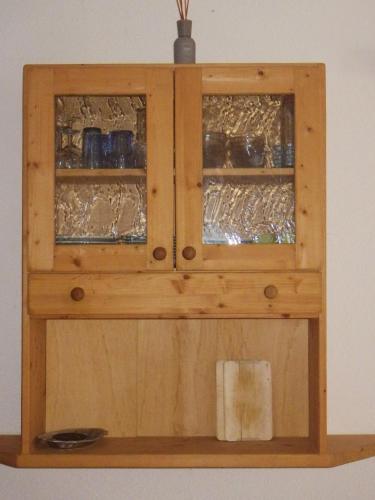 a wooden cabinet with glass doors on a wall at Haus Thomas in Telfs