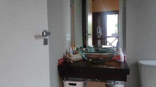 a bathroom with a glass bowl sink on a counter at Casa com serviço de praia e piscina privativa, Juquehy! in Juquei