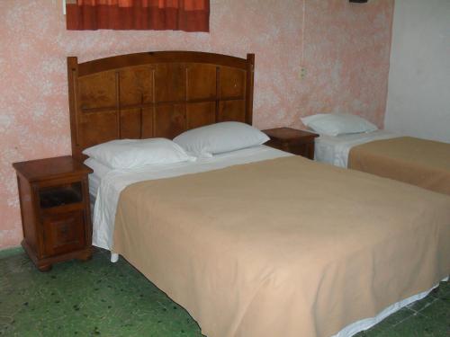um quarto com duas camas e duas mesas de cabeceira em Hotel San Jose em Mérida