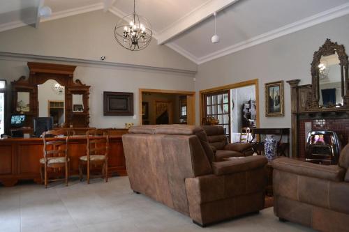 uma sala de estar com um sofá e uma mesa em Hobbit Boutique Hotel em Bloemfontein