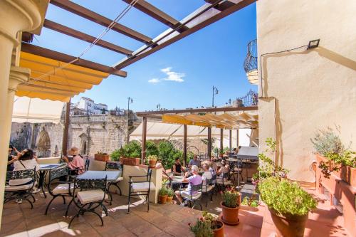a group of people sitting at tables on a patio at Hotel Don Miguel in Ronda