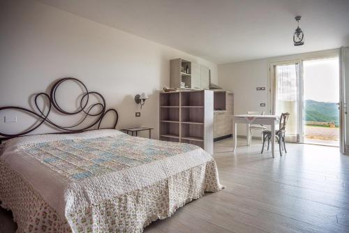 Un dormitorio con una cama y una mesa con sillas. en Il Pavone Errante, en Ciola
