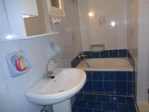 a bathroom with a sink and a bath tub at Loutra House Kythnos in Loutra