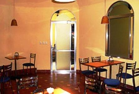 un comedor con mesas y sillas y una puerta en Hotel San Jose, en Mérida