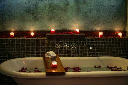 a bathroom with a bath tub with candles in it at Rodavento Boutique Hotel & Spa in Valle de Bravo