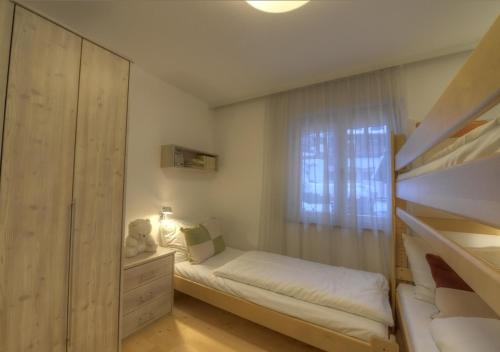 niewielka sypialnia z łóżkiem piętrowym i oknem w obiekcie Chalet Anna Maria by Kaprun Rentals w Kaprunie
