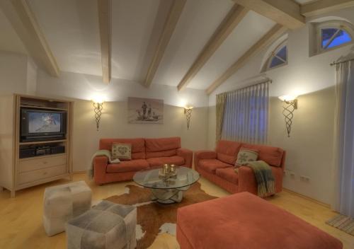 a living room with two couches and a tv at Chalet Anna Maria by Kaprun Rentals in Kaprun