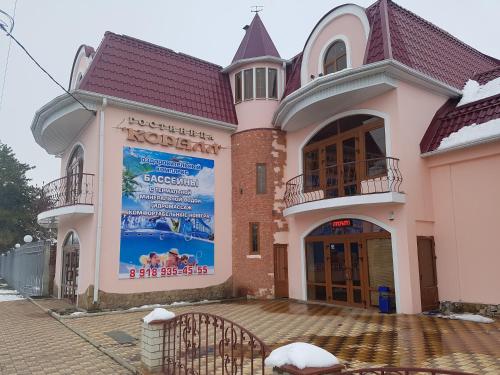 a large building with a sign on the front of it at Mini-Hotel Coral Family in Mostovskoy