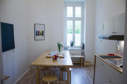 a kitchen with a wooden table in a room at Central , 3 rooms in Frankfurter Tor in Berlin