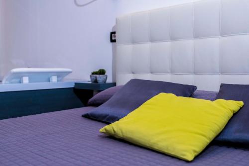 cuscino giallo seduto sopra un letto di balai suite a Porto Torres