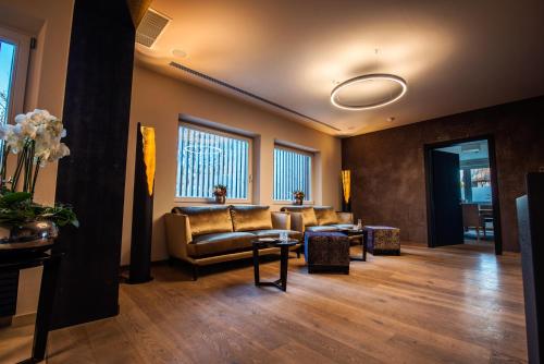 a waiting room with couches and tables and windows at Alpenrose Kufstein in Kufstein