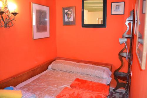 niewielka sypialnia z pomarańczową ścianą i łóżkiem w obiekcie Casa LOS ANGELES w mieście Villajoyosa