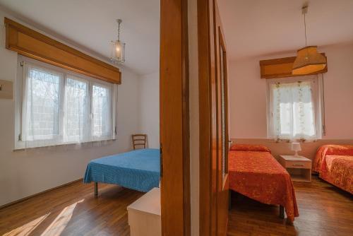 ein Zimmer mit 2 Betten und ein Schlafzimmer mit 2 Fenstern in der Unterkunft Villa Bellavista in Ledro