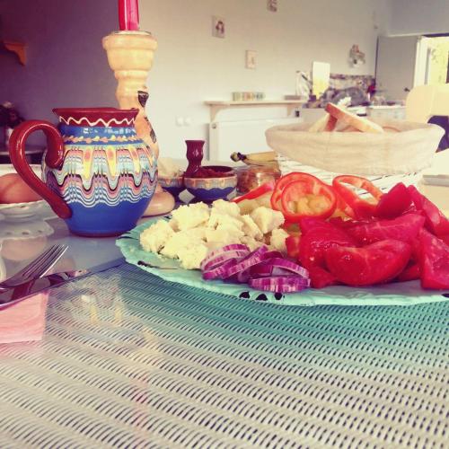 a plate of vegetables on a table with a vase at Pensiunea Grădina Ascunsa in Bughea de Jos